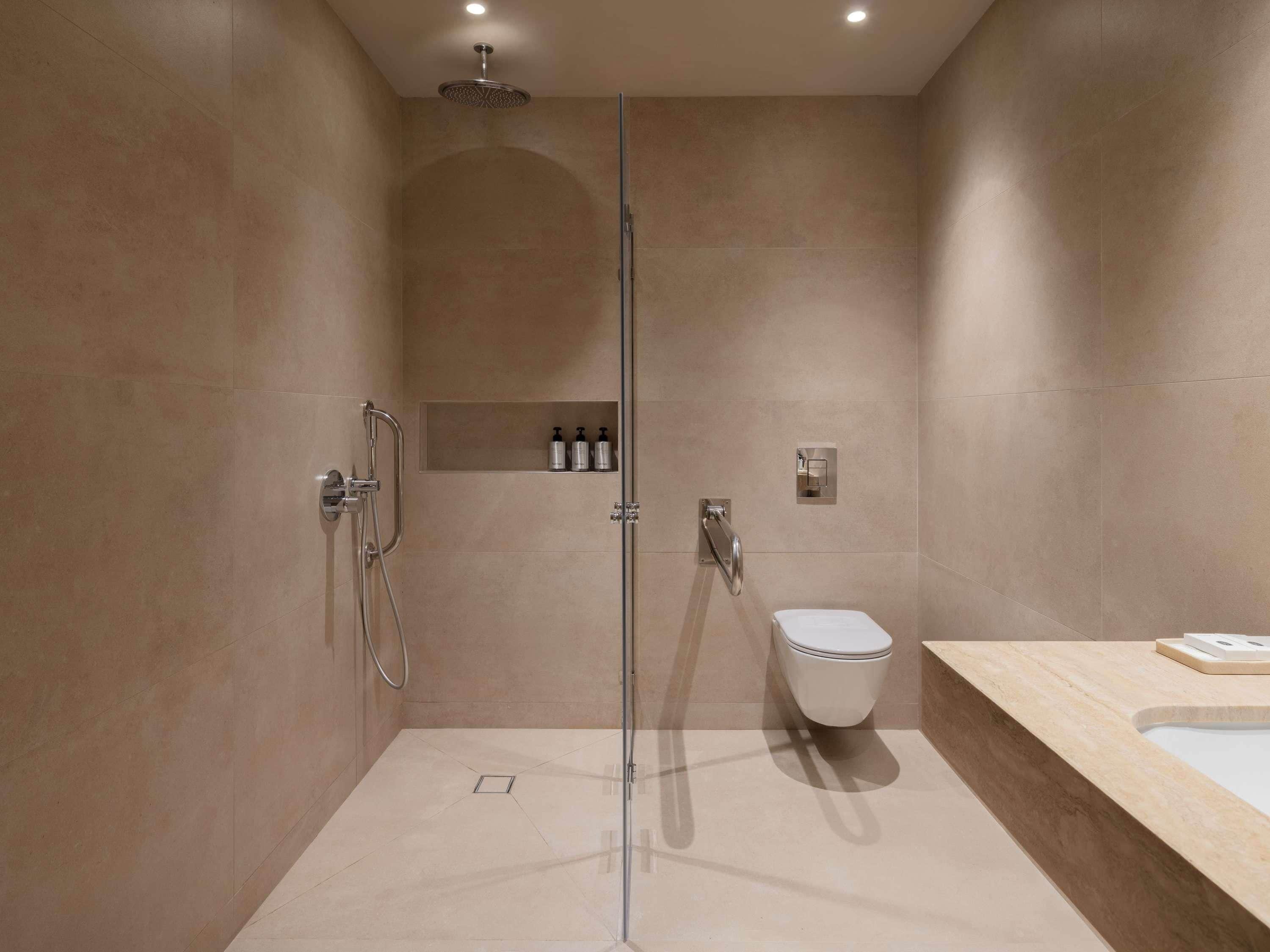 Une salle de bain moderne avec une douche à parois de verre, des toilettes et un meuble-lavabo avec un miroir.