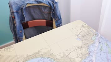 Un mapa con una chaqueta vaquera colgada sobre una silla.