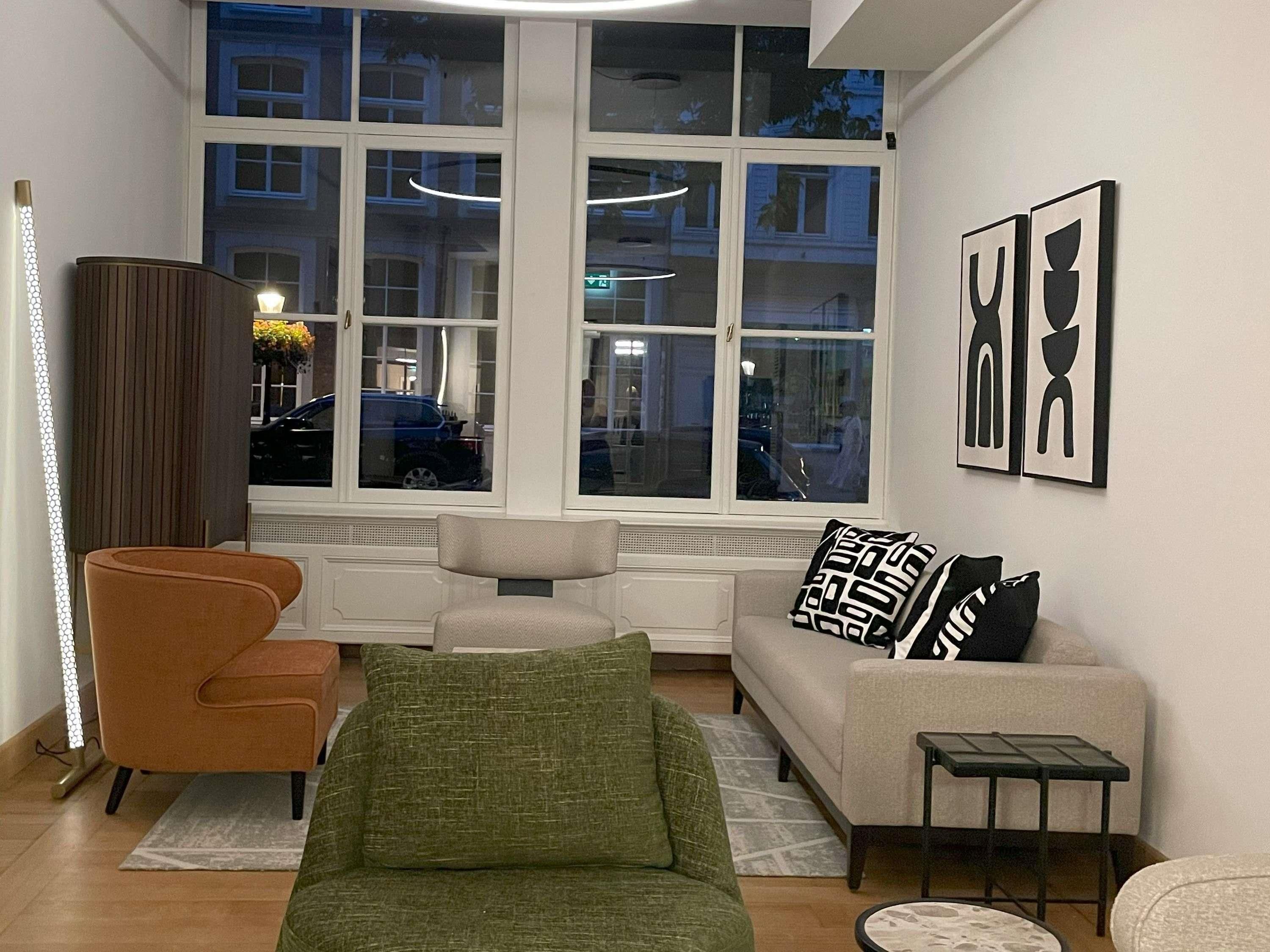 Una sala de estar moderna con sofá, sillón y una mesita.