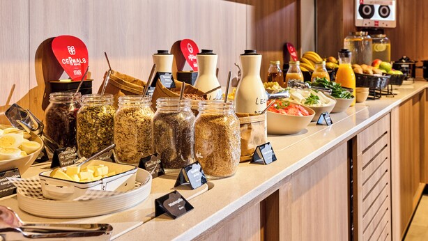 A breakfast buffet with various food items and condiments. - ibis Madrid Norte Las Tablas (Madrid)
