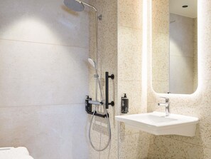 A modern bathroom with a shower, a sink, and a mirror. - Ibis Styles Marseille Palais Des Congrès Vélodrome (Marseille)