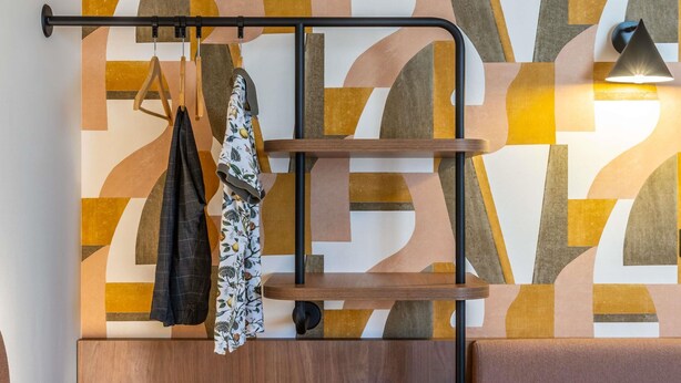A wall-mounted shelf with hanging clothes and a backpack. - Ibis Styles Marseille Palais Des Congrès Vélodrome (Marseille)