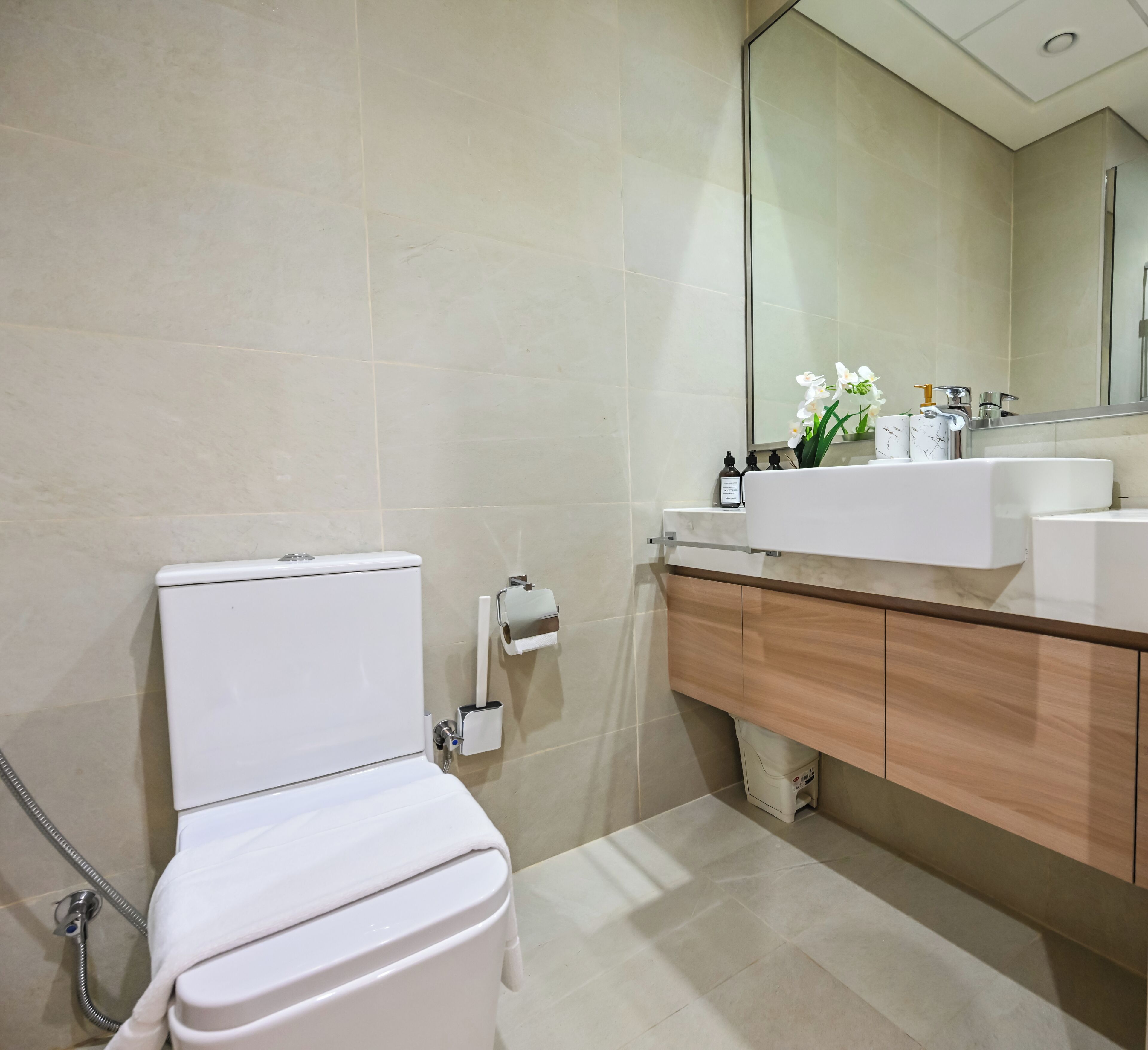 A modern bathroom with a toilet, sink, and mirror.