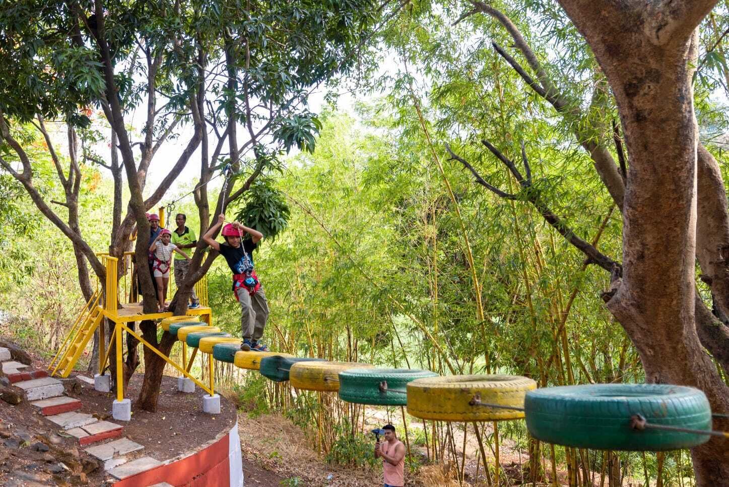 A tree-based obstacle course with participants and a guide.