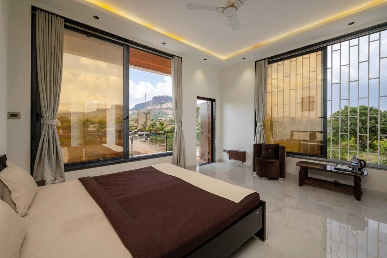 Une chambre moderne avec un grand lit, des portes-fenêtres coulissantes donnant sur un balcon et une vue sur l’extérieur.