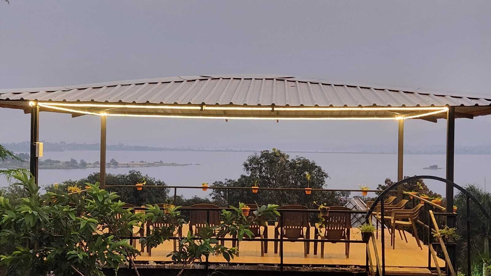 An outdoor seating area with a metal roof and potted plants.