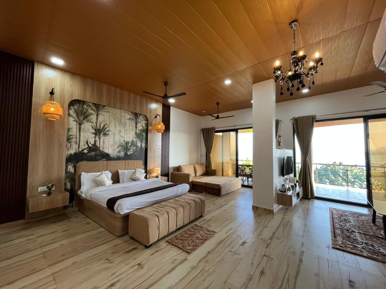 Une chambre spacieuse avec un grand lit, un canapé et un balcon offrant une vue agréable.