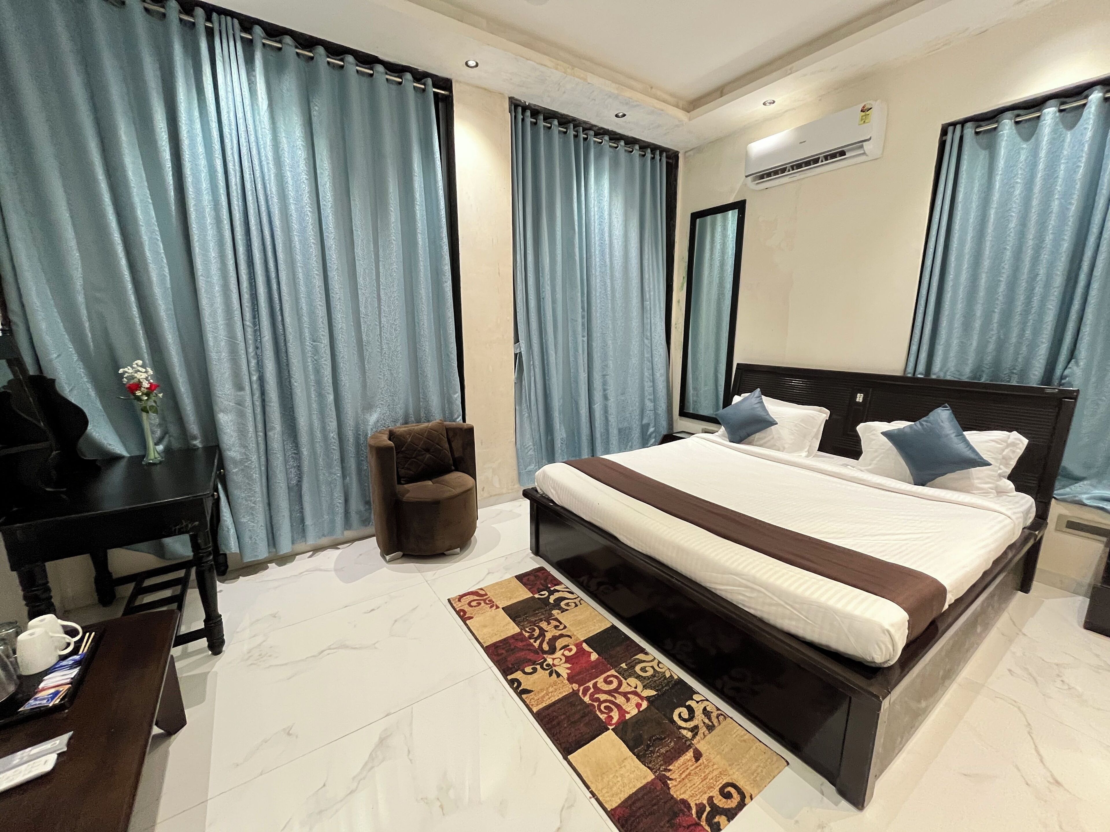 Ein Hotelzimmer mit Bett, Schreibtisch, Stuhl und kleinem Tisch.
