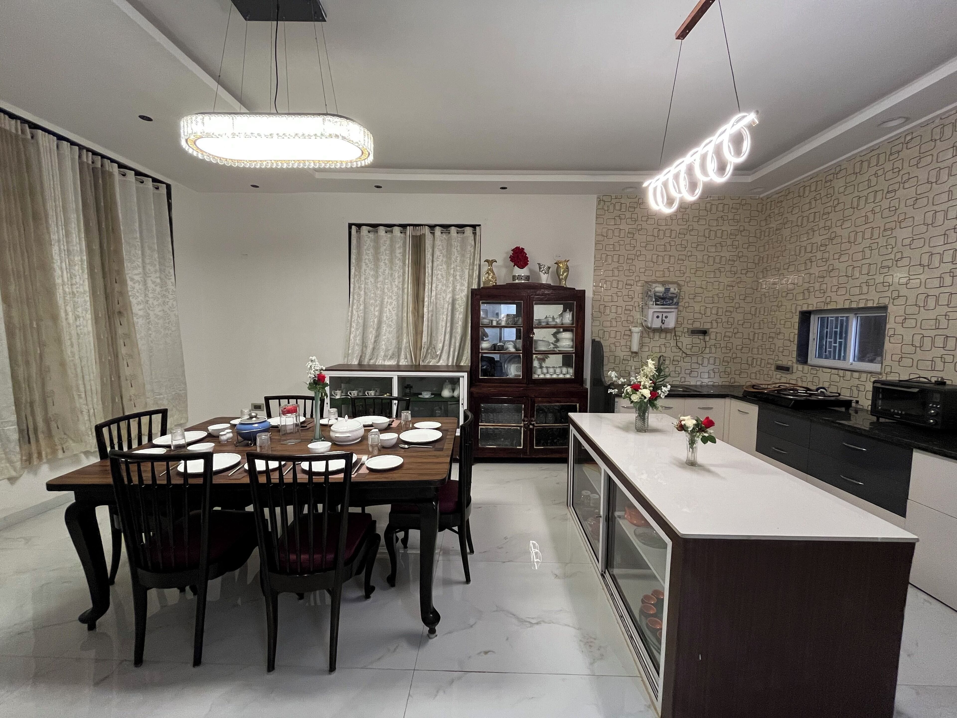 A dining area with a wooden table, chairs, and a cabinet with glass doors.