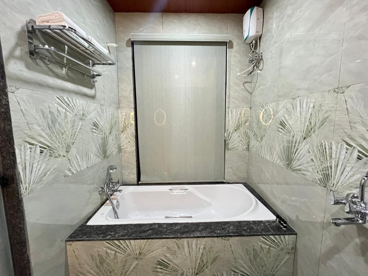 A bathroom with a freestanding bathtub, a towel rack, and a wall-mounted mirror.
