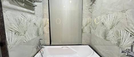 A bathroom with a freestanding bathtub, a towel rack, and a wall-mounted mirror.