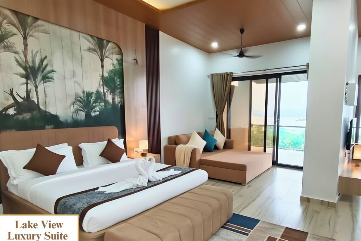 A spacious room with a large bed, a sofa, and a view of the outdoors.