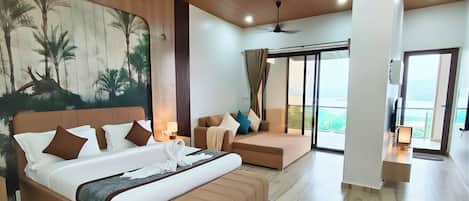 A spacious room with a large bed, a sofa, and a view of the outdoors.