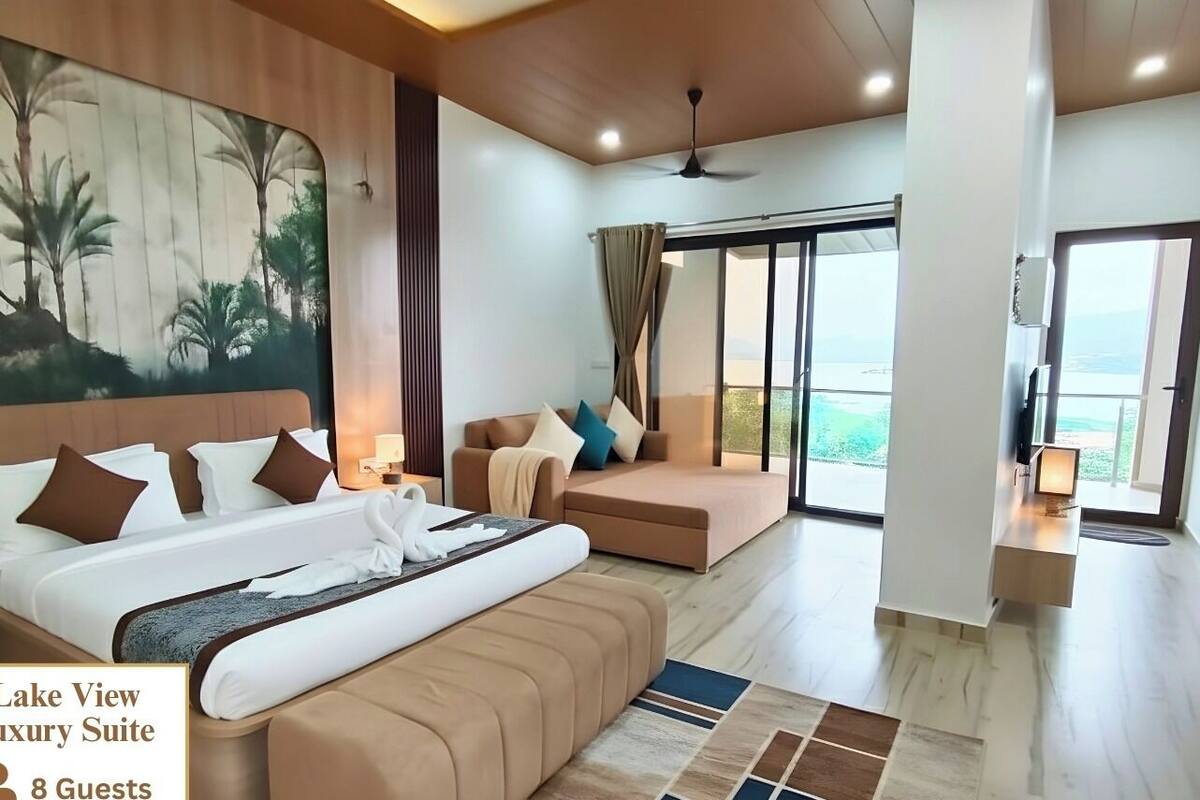 A spacious room with a large bed, a sofa, and a view of the outdoors.