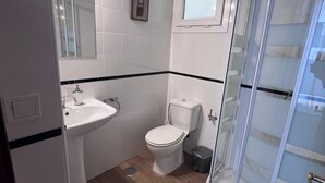 A bathroom with a sink, toilet, and a glass-enclosed shower area. - Apartment 2nd left (1 Bedroom) (Sevilla)