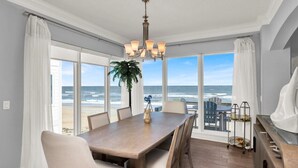 A dining area with a view of the ocean, a chandelier, and a plant on the table. - Vitamin Sea - 2779   “Ponte Vedra” (Ponte Vedra Beach)