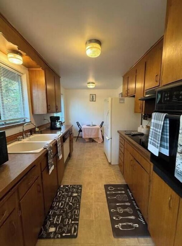 Effortlessly prepare meals in this well-equipped kitchen with a central island, sink, stove, and refrigerator.