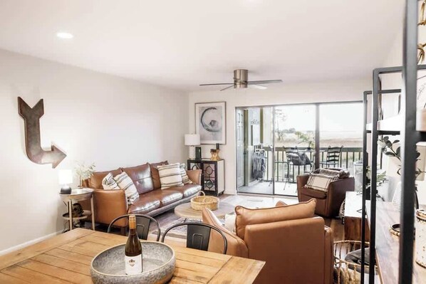 A modern living room with a sofa, coffee table, and dining area.