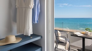 Ein Balkon mit Blick auf das Meer, ein Tisch mit einem Buch und einer Tasse sowie ein Stuhl.