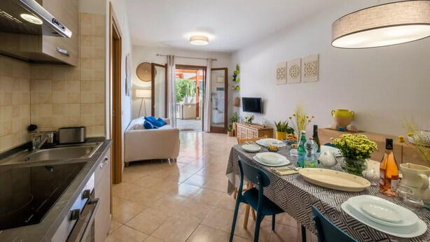 A modern kitchen with a dining area, a sofa, and a television. - Villaelena in Marittima (Marittima)