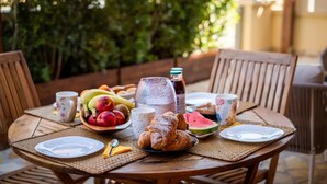 A round wooden table set for breakfast with fruits, pastries, and beverages. - Villaelena in Marittima (Marittima)