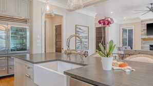 A modern kitchen with stainless steel appliances, a double sink, and pendant lighting. - Immaculate new Rhett's Bluff property (Kiawah Island)