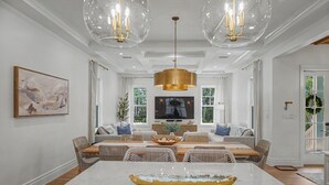 A spacious dining area with a marble table, wicker furniture, and pendant lighting. - Stunning Down-to-the-Studs Remodel  – Across from Camp WaterColor (Santa Rosa Beach)