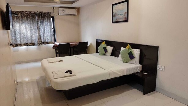 Una habitación de hotel con cama, escritorio, silla y televisión.