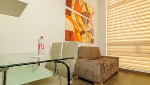 A modern living room with a glass table, a brown sofa, and abstract art on the wall. - NOK Spacious Duplex in Parque 93 (Bogotá)