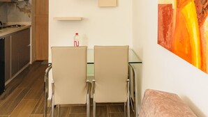 A modern kitchen with a dining area, a loft bedroom, and a large abstract painting on the wall. - NOK Spacious Duplex in Parque 93 (Bogotá)