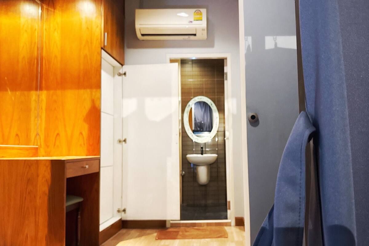 A bathroom with a wooden vanity, a sink with a mirror, and a shower curtain.