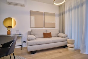 Relax in this stylish living space with a sofa, dining area, and ample natural light.