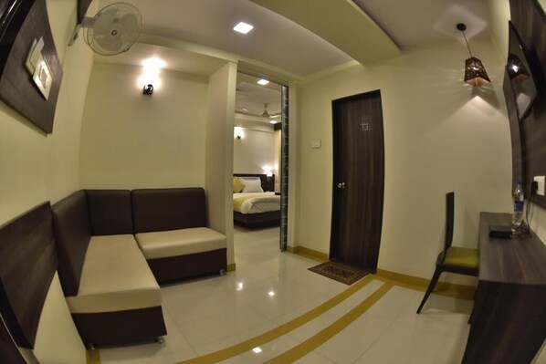 A modern hotel room with a sofa, a desk, and a bed. - Hotel Time Square (Thane)