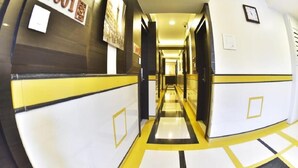 A hotel corridor with a check-in counter, a clock, and a sign indicating room number 1001. - Hotel Time Square (Thane)