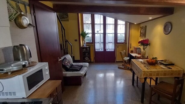 Une cuisine compacte équipée d’un four à micro-ondes, d’une table à manger avec des chaises et d’un canapé.