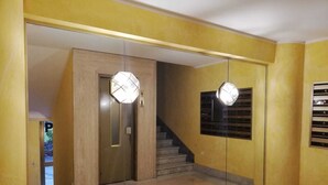 Ein Flur mit einer Spiegelwand, einer Holztür und einer Treppe.