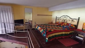 Une chambre à coucher avec un lit, un bureau, une chaise et une fenêtre avec des rideaux.