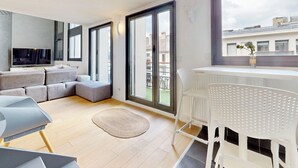 Un appartement moderne doté d’un espace de vie, d’un balcon et offrant une vue sur la ville.