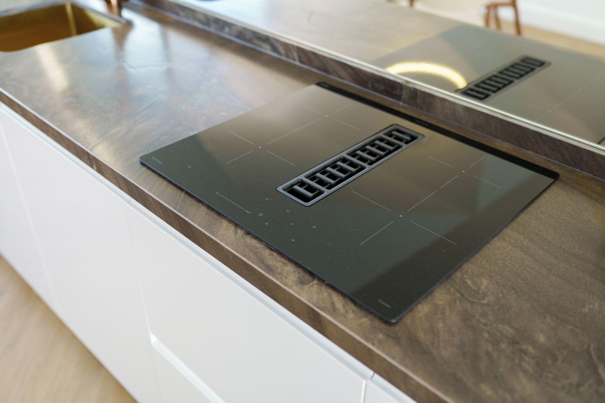 Una cocina con encimera moderna de acero inoxidable y extractor empotrado.