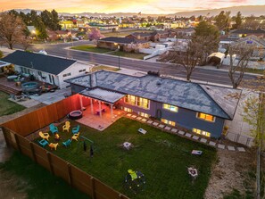 Un quartier résidentiel avec des maisons, une piscine et une terrasse aménagée avec du mobilier d’extérieur.