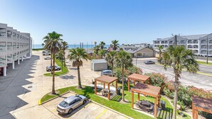 Un hôtel doté d’un parking, de palmiers et offrant une vue sur la plage.