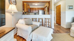 A cozy bedroom with a bed, bedside tables, and a lamp. - Sandy Oceanfront 2nd FL 1BR W/pool at The Riggings (Kure Beach)