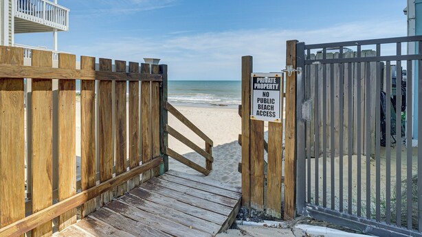 A wooden beach gate with a sign indicating no public beach access. - Sandy Oceanfront 2nd FL 1BR W/pool at The Riggings (Kure Beach)