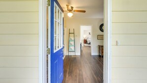 A hallway with wooden flooring, a blue door, and a ceiling fan. - 8 Mi to Columbia River Gorge: Cottage w/ Deck! (Gresham)