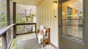 A wooden porch with a bench, a door with a window, and a wooden railing. - Walk to Hiking & Skiing: Beech Mountain Condo (Banner Elk)