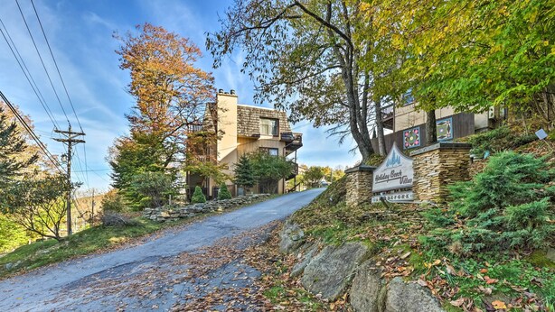 A stone building with a sign reading "Holiday Resort Villa" and a paved road with fallen leaves. - Walk to Hiking & Skiing: Beech Mountain Condo (Banner Elk)