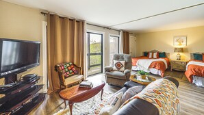 A hotel room with a TV, a sofa, a chair, a bed, and a window. - Walk to Hiking & Skiing: Beech Mountain Condo (Banner Elk)