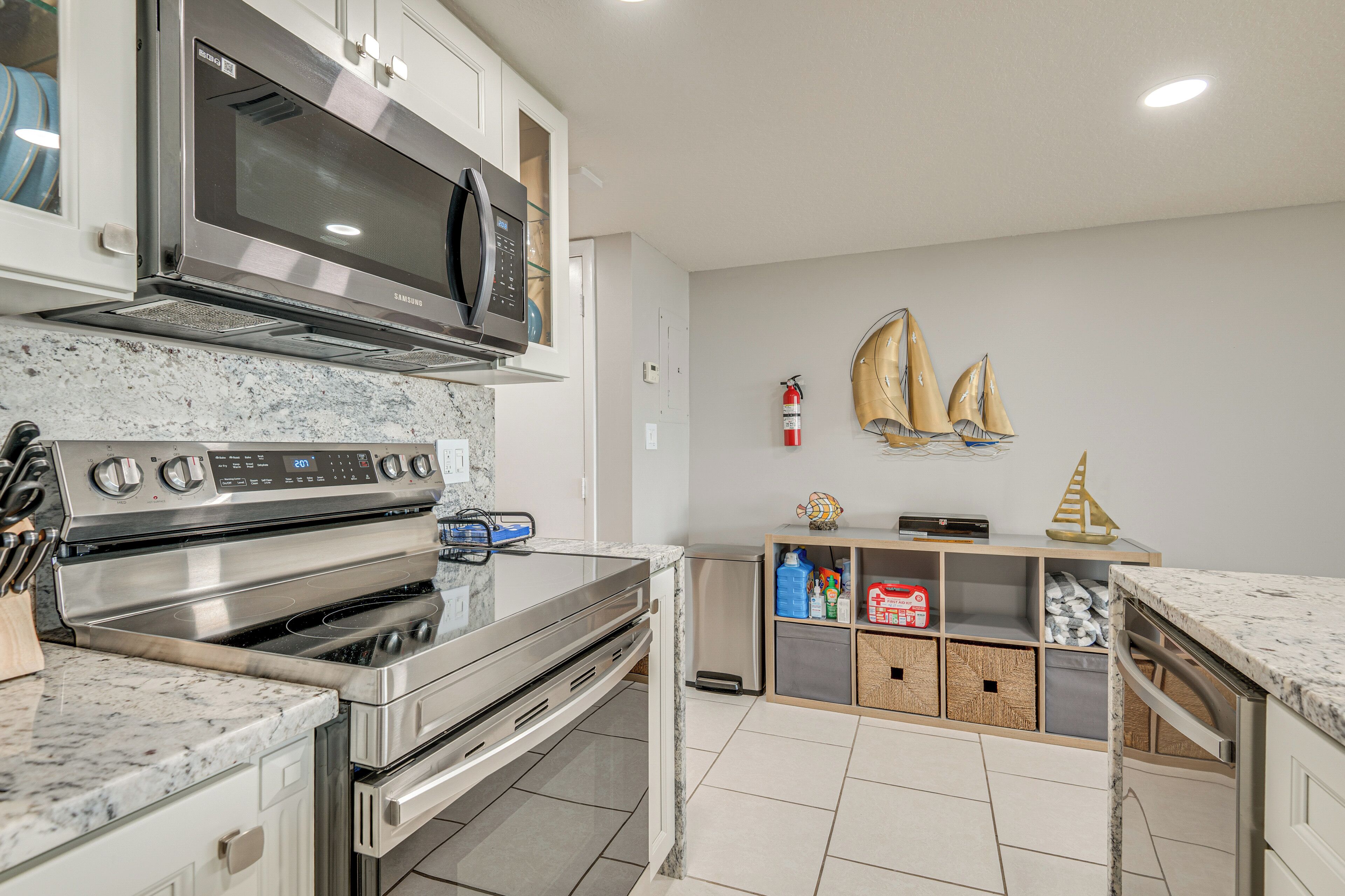 Een moderne keuken met roestvrijstalen apparatuur, een marmeren aanrechtblad en een houten kast met opbergruimte.