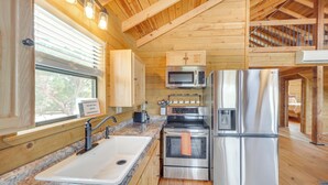 A kitchen with stainless steel appliances, a granite countertop, and wooden walls. - Pet-friendly Hideaway 13 Mi to Leakey (Leakey)