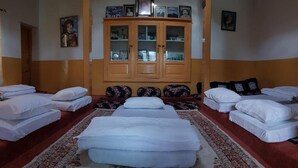 A hotel room with a large bed, a cabinet with glass doors, and a patterned rug.